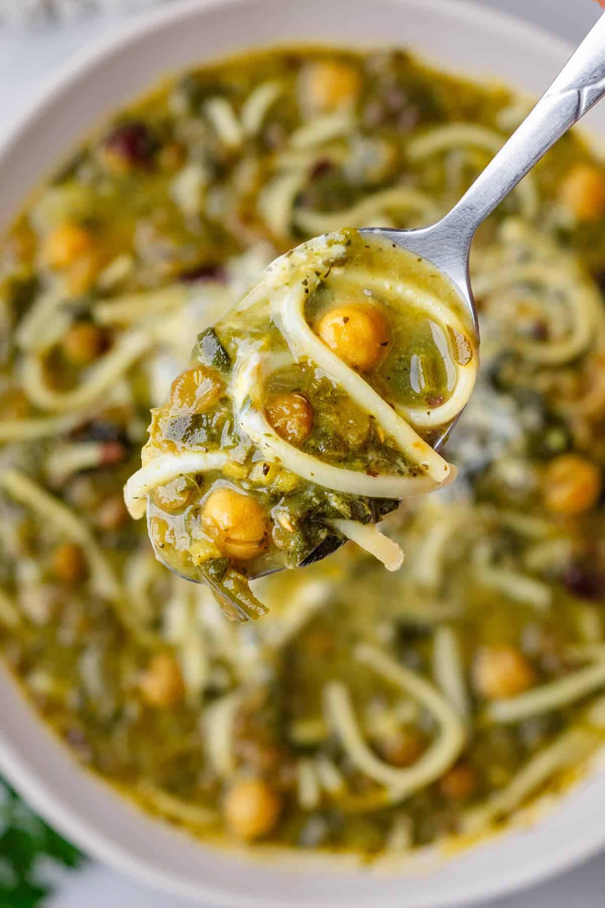 Close-up of reshteh noodles being added to a pot of soup