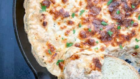 close-up of creamy crab dip in a small oven-safe skillet before baking