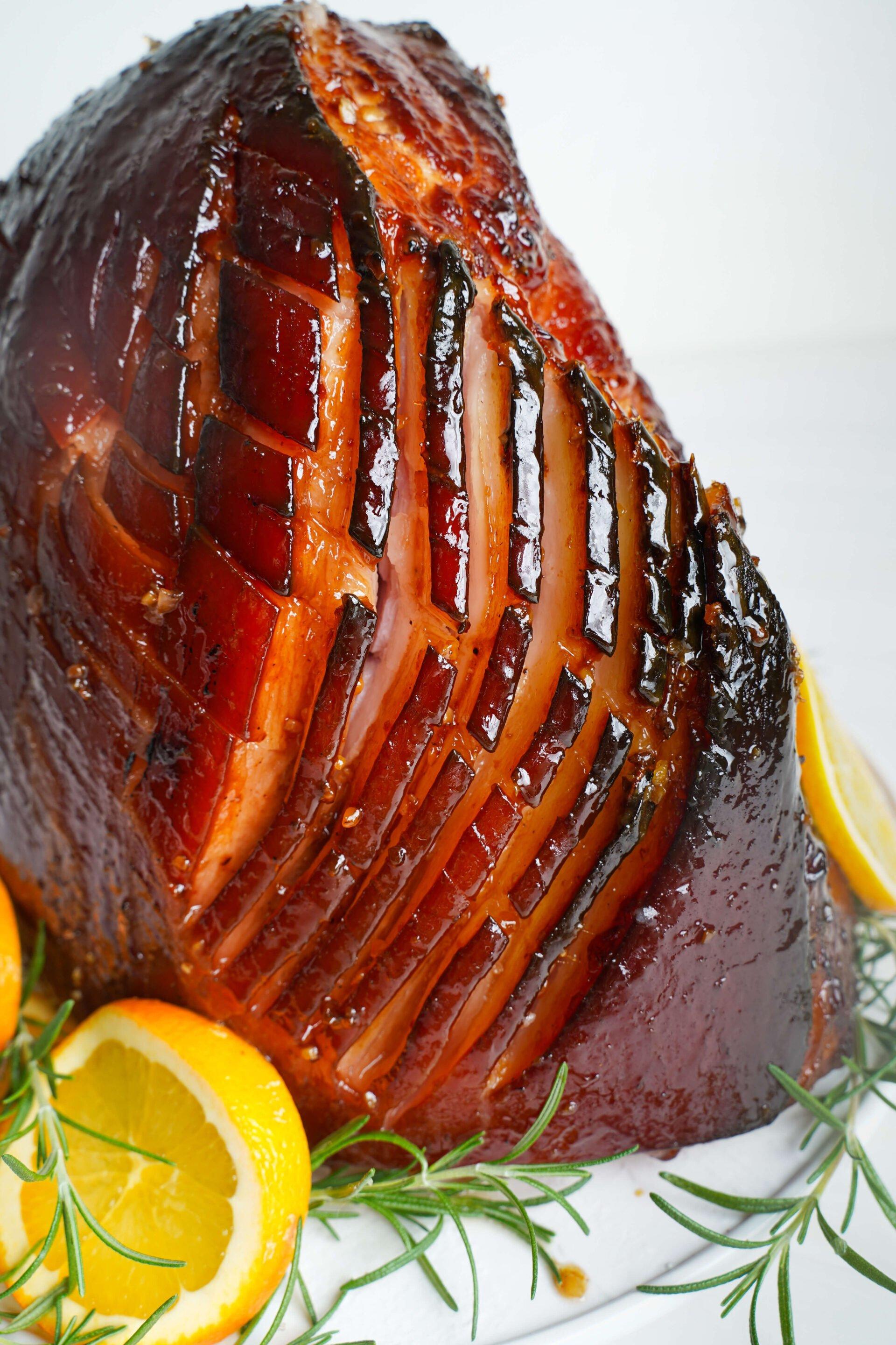 Close-up of the ham glazing process, showing the rich, dark glaze