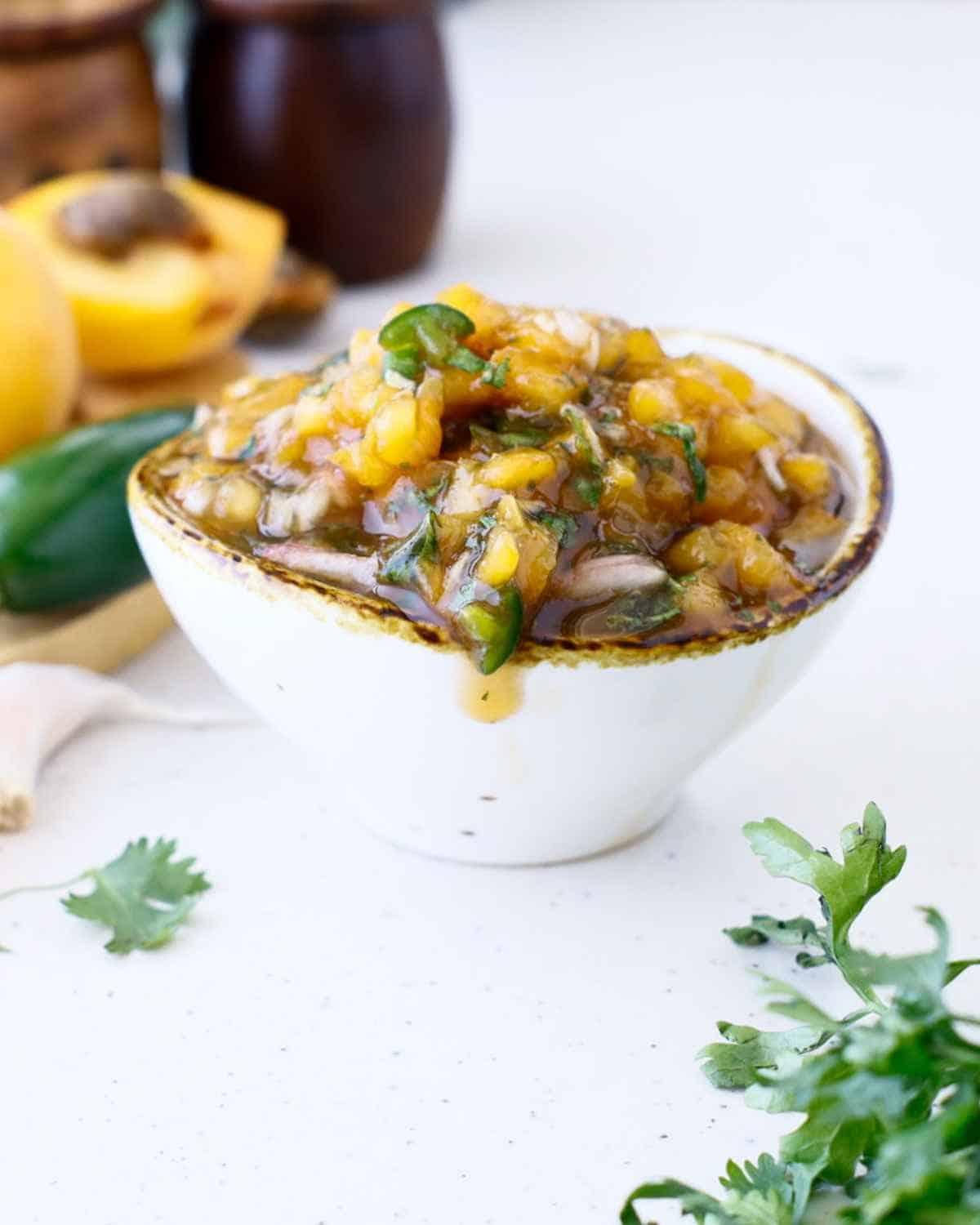 Close-up shot of apricot and almond salsa in a glass bowl