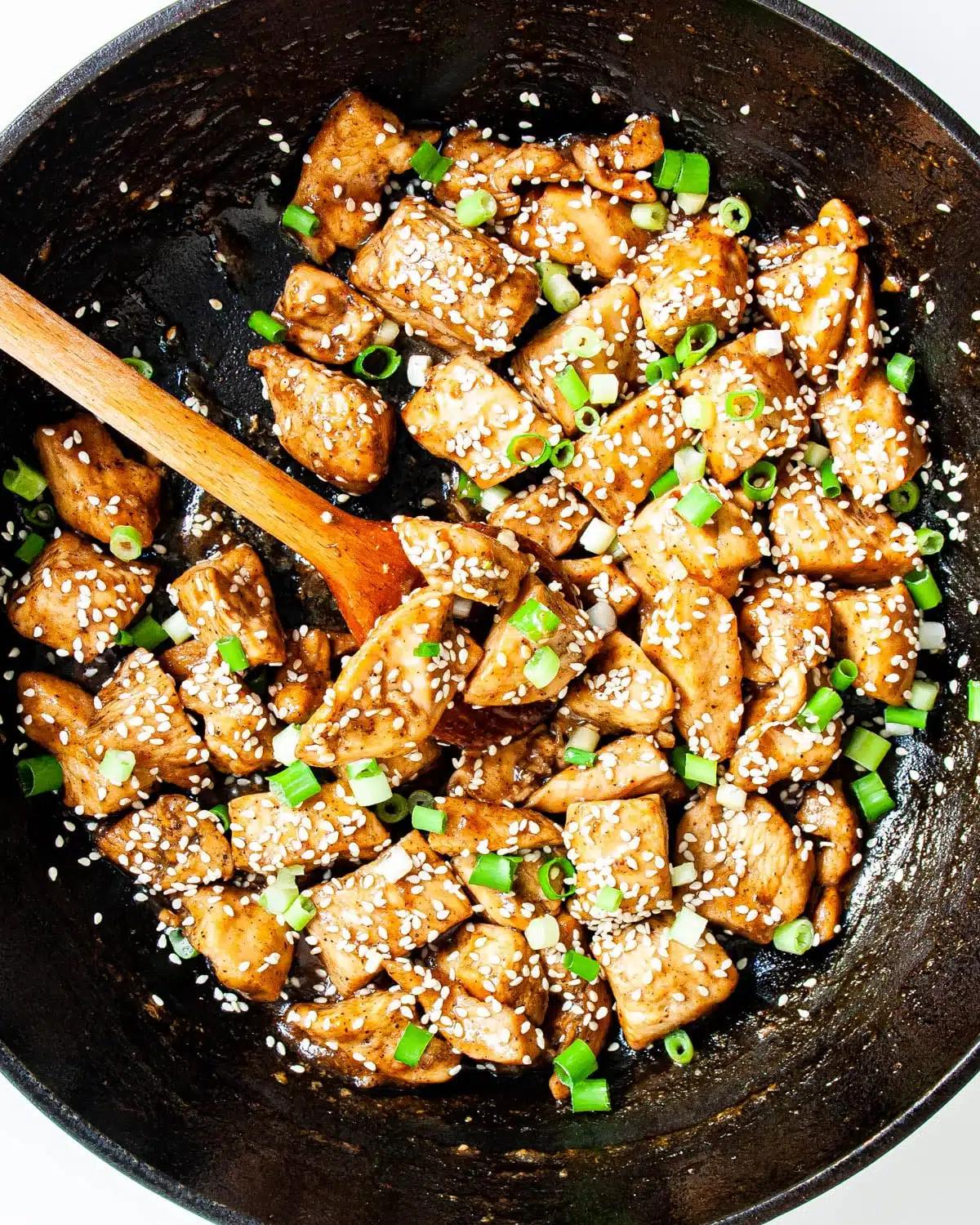 Overhead shot of a skillet containing a freshly baked Japanese Teriyaki Chicken Frittata, garnished with green onions and sesame seeds