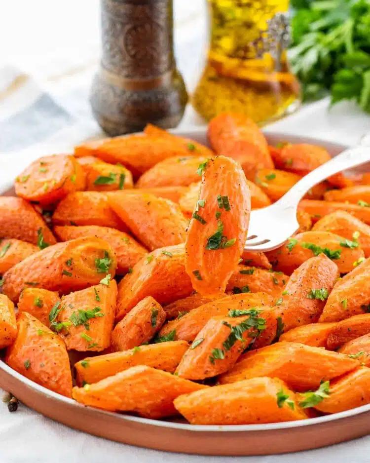 A shallow roasting pan filled with glazed carrots, fresh out of the oven, slightly caramelized edges