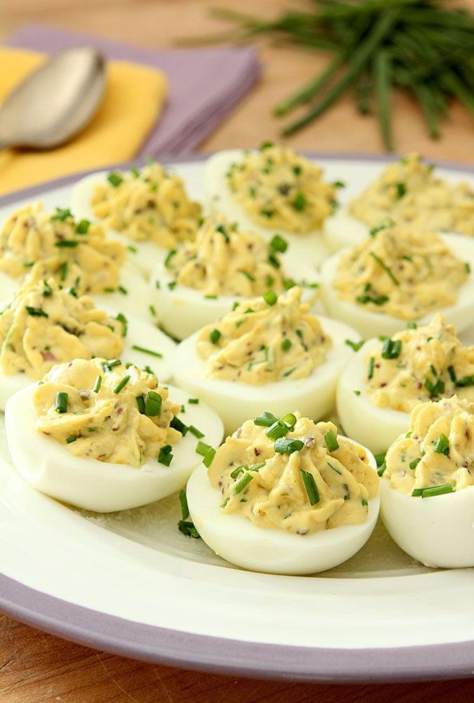 Close-up of elegant deviled eggs garnished with gin and tonic, herbs and citrus zest