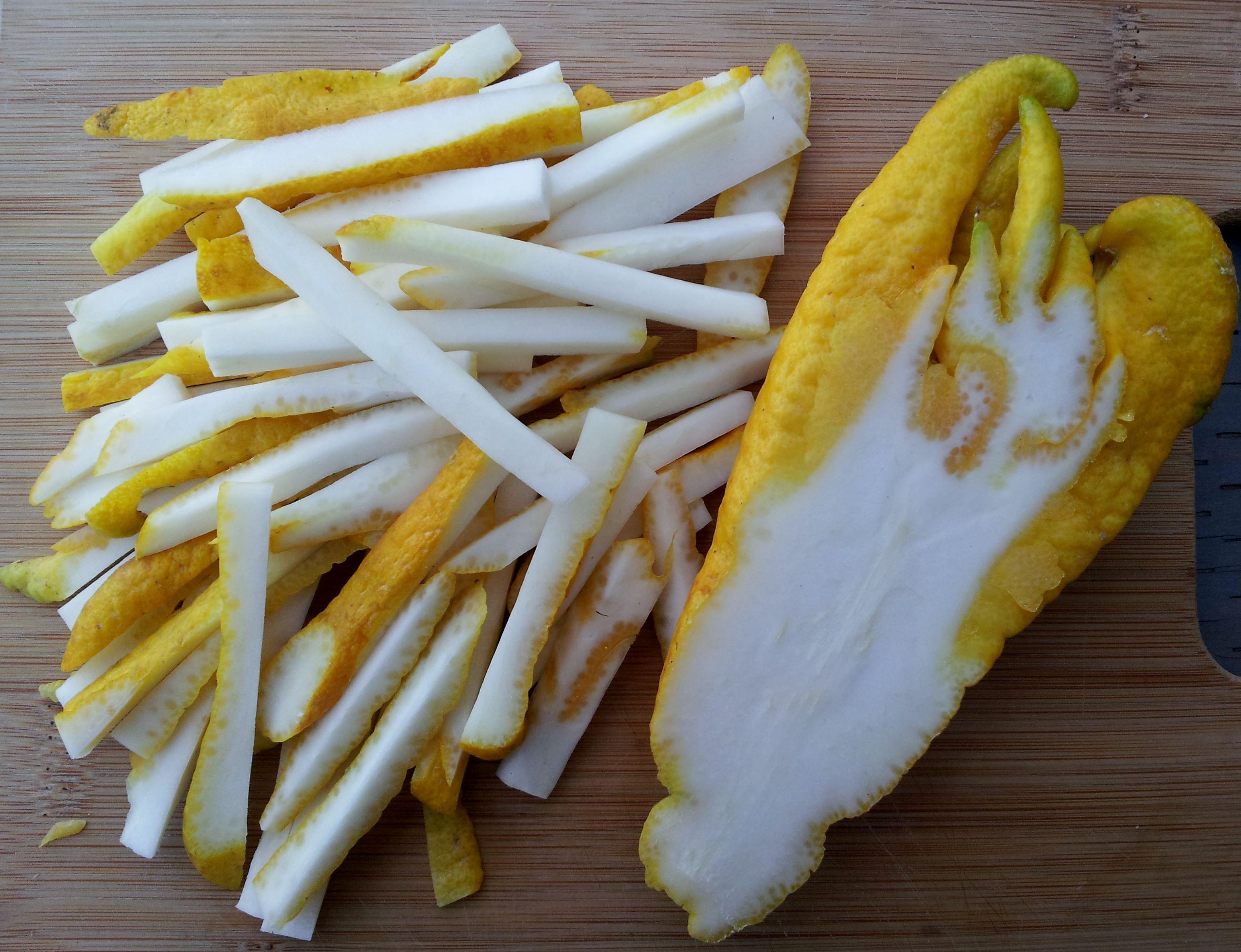 Buddha's Hand fruit cut open, showing segments, next to a blender
