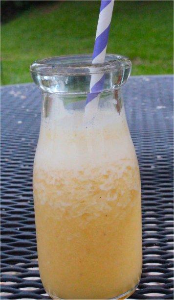 Ugli fruit smoothie in a glass with slices of Ugli fruit around it