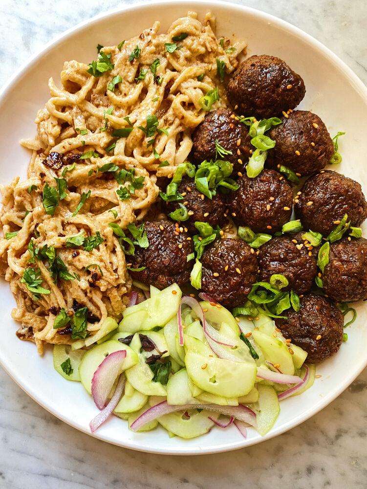 Spicy Peanut Noodles with Plant-Based Meatballs on a wooden table