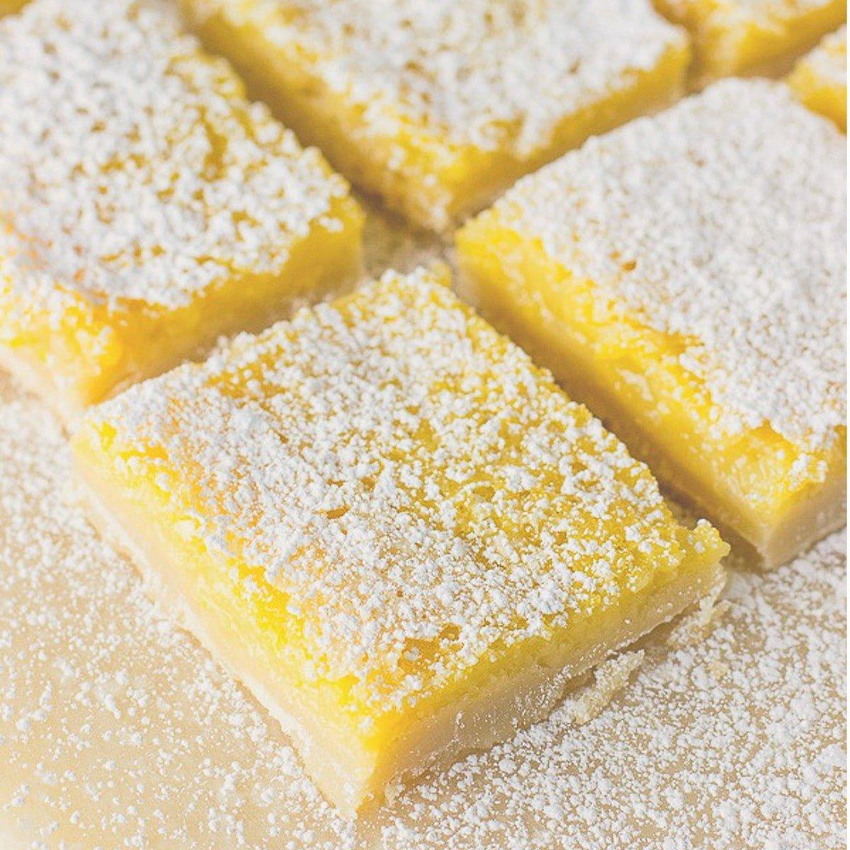 lemon bars arranged on a platter with powdered sugar dusting