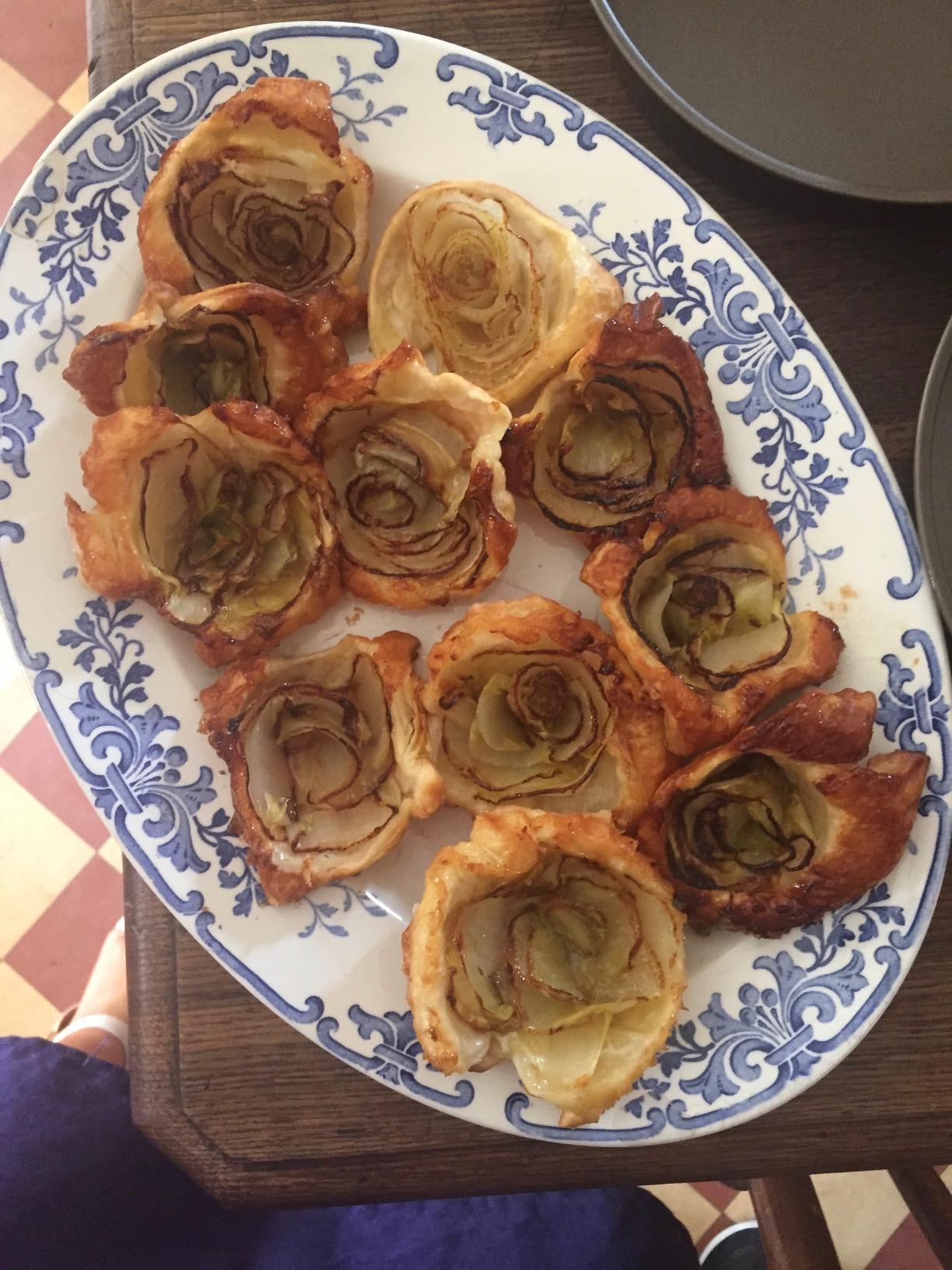 overhead shot of Endive Enchantment Tartlets arranged on a rustic wooden table with thyme sprigs