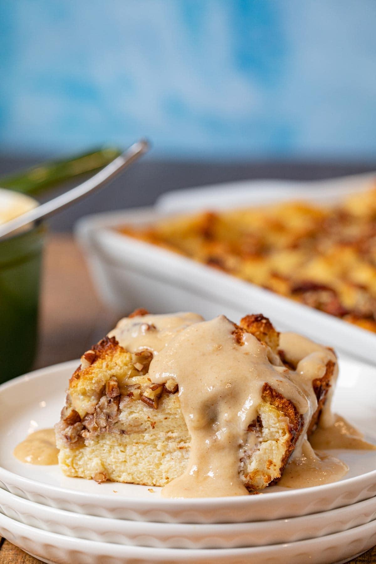 Close-up shot of a spoonful of bourbon pecan bread pudding being lifted from a baking dish.
