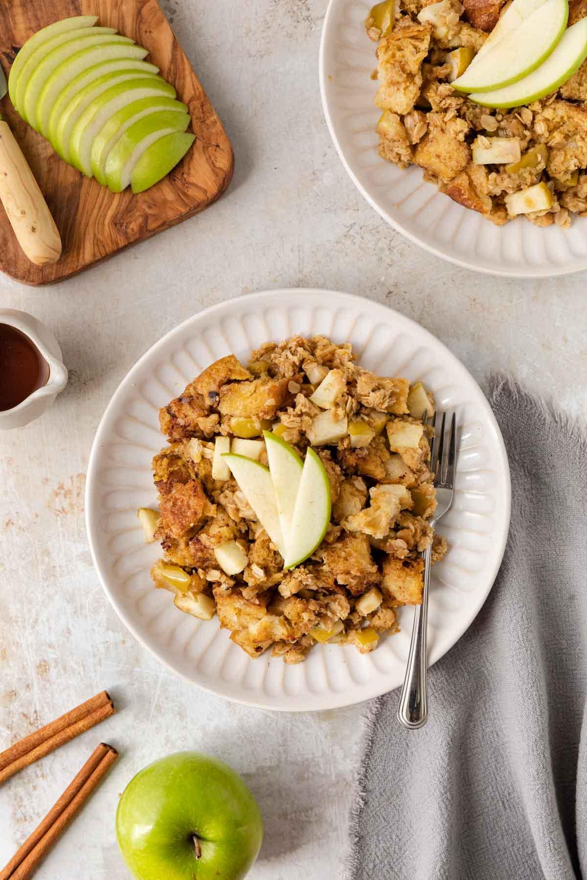 Close-up shot of a slice of Apple Crisp French Toast Casserole, showing the layers of bread, apples, and oat topping