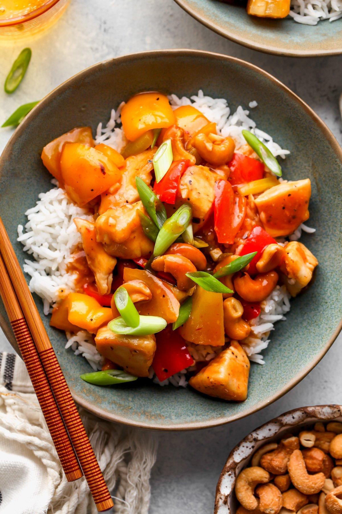 finished sweet and sour chicken dish in a bowl with rice and chopsticks