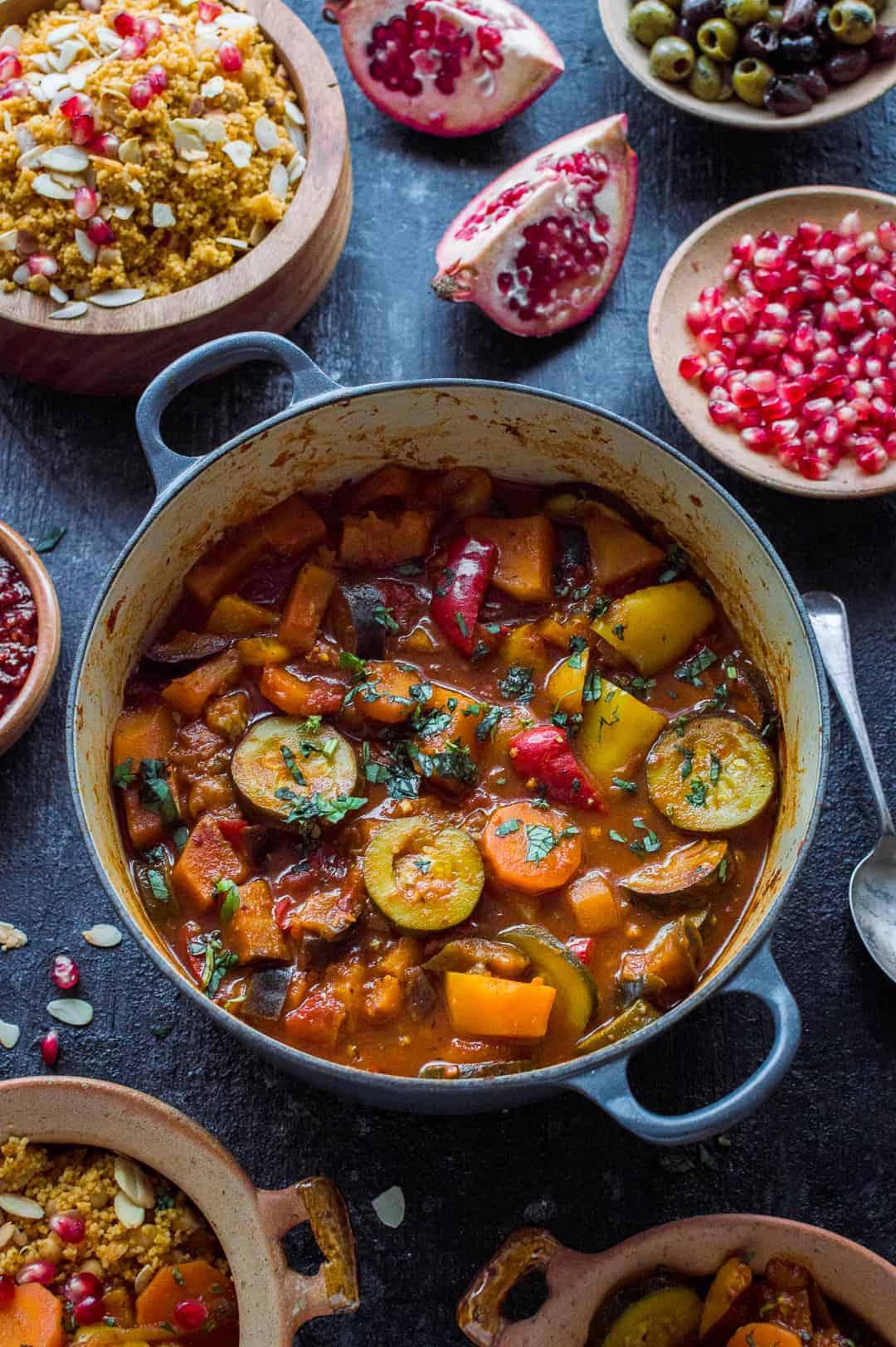 a person serving vegetable and tofu tagine over couscous