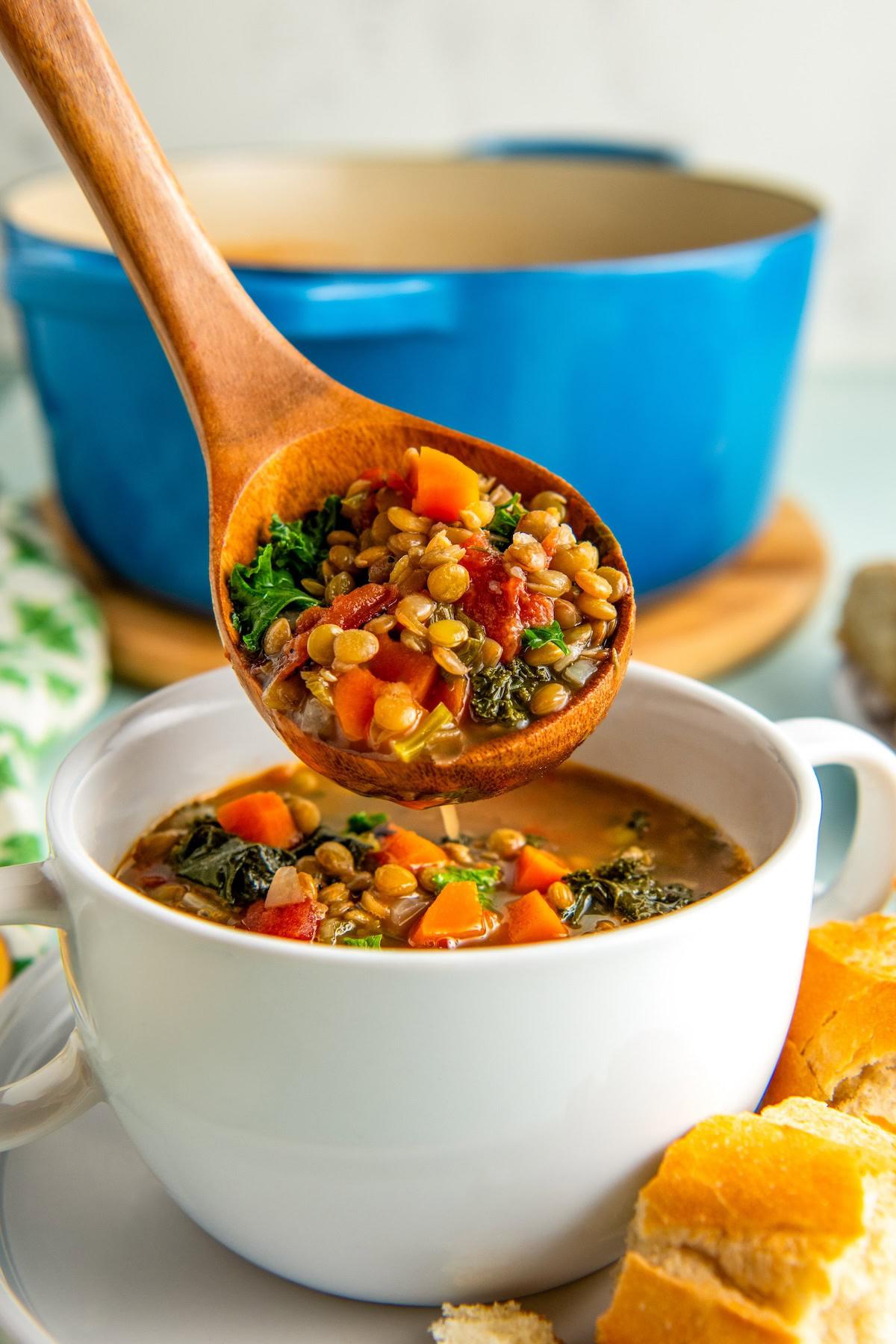 Bowl of lentil soup with crusty bread and fresh parsley garnish