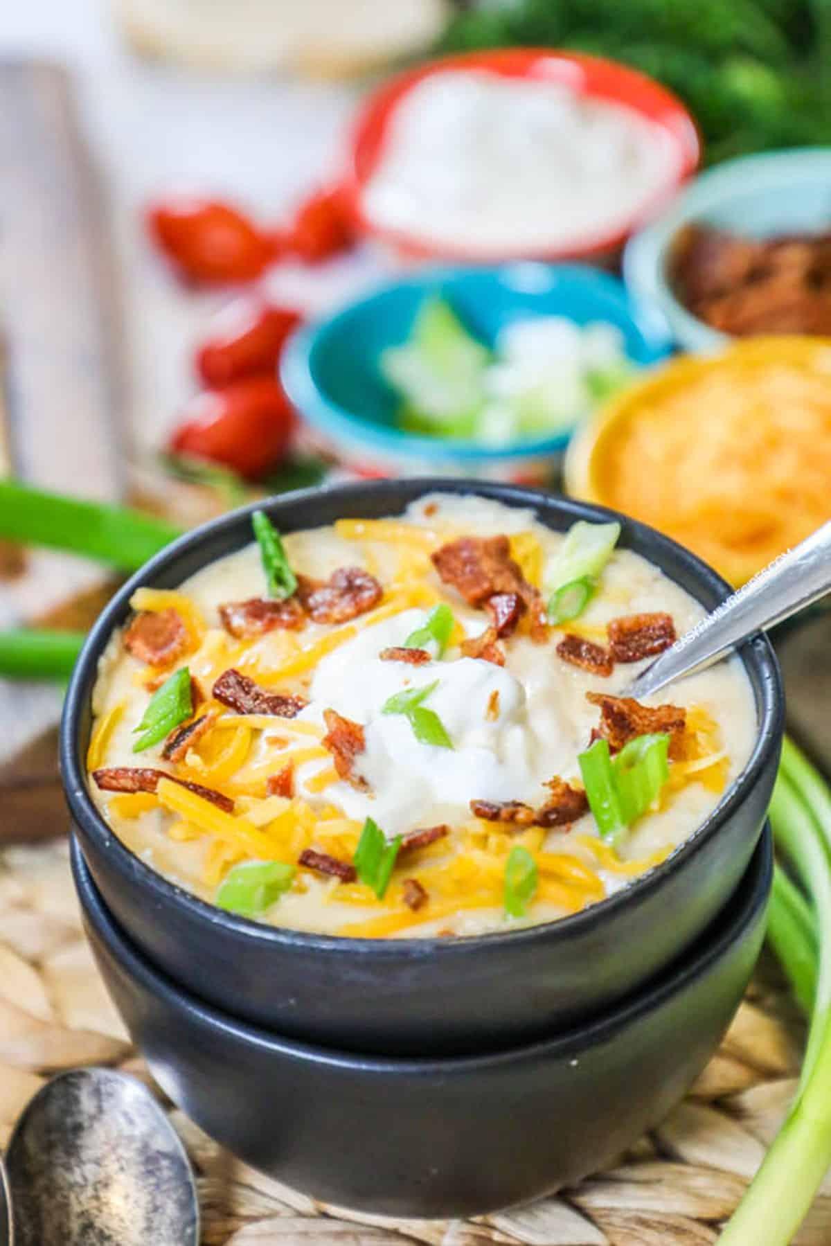 A close-up of a steaming bowl of loaded potato soup
