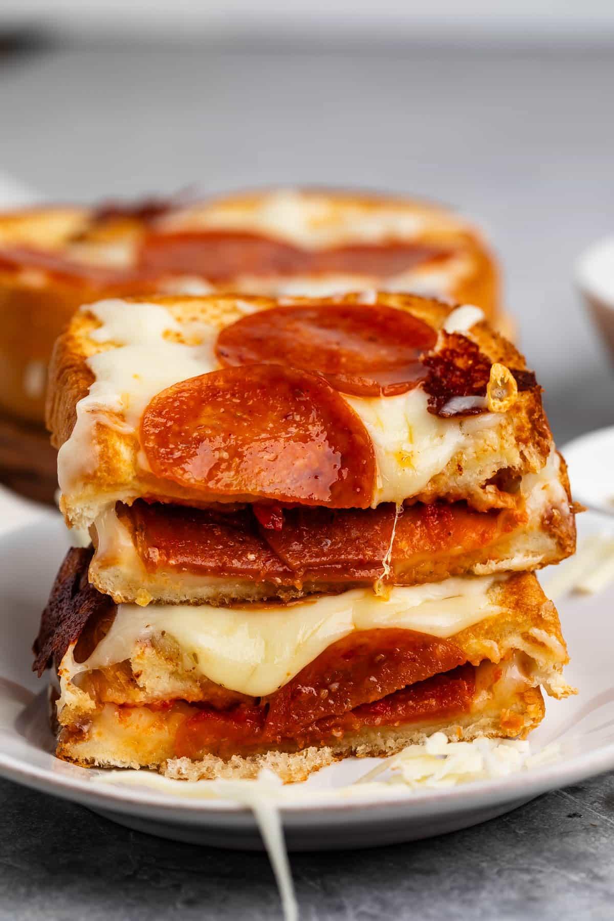 Side view of a perfectly grilled pizza grilled cheese, showing melted cheese and pepperoni inside
