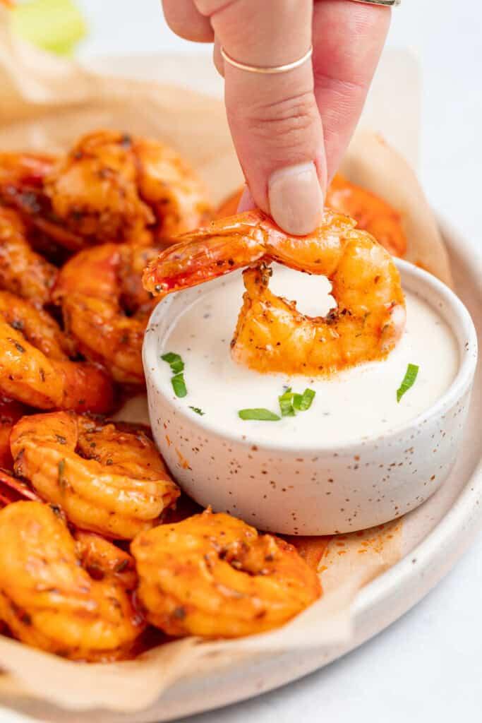 Close-up shot of buffalo shrimp drizzled with celery ranch dressing