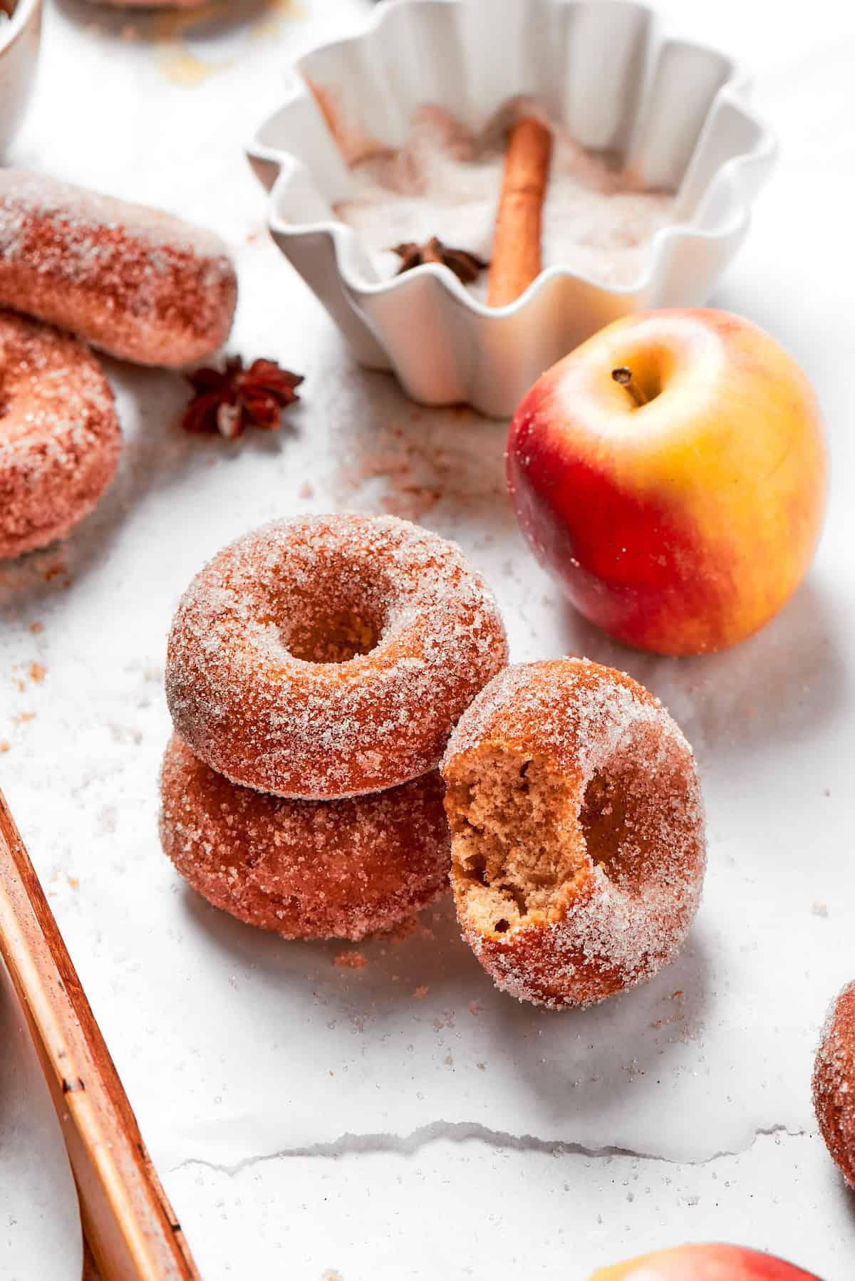 stack of spiced apple cider donuts with a cup of coffee