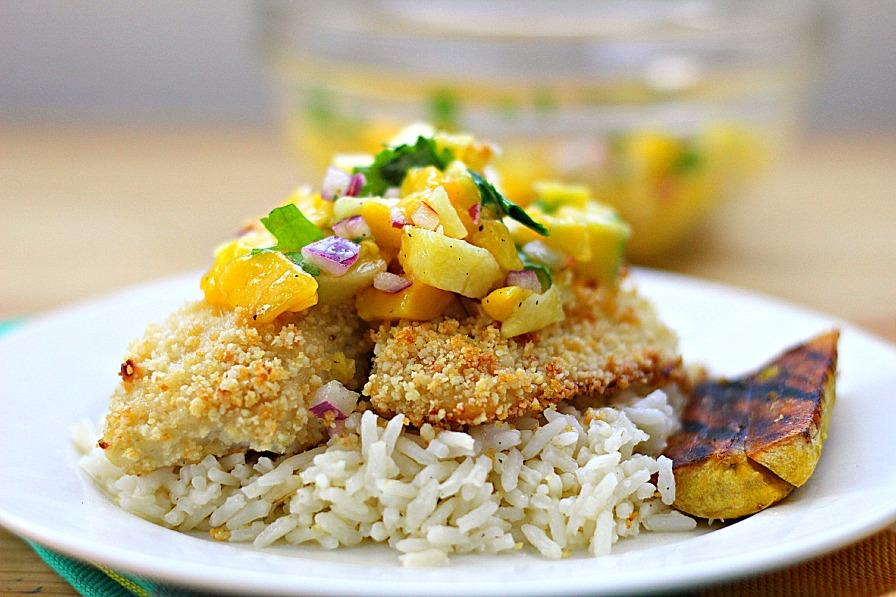 a person serving macadamia nut and pineapple salsa on grilled fish