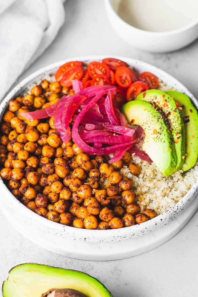 close-up shot of a bowl of curried chickpea cauliflower rice with a spoon taking a scoop