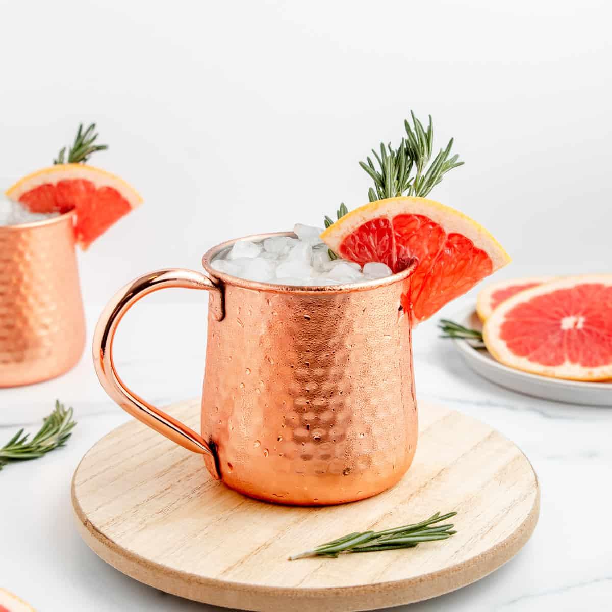 grapefruit Moscow Mule in a copper mug with grapefruit slices and mint garnish