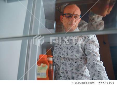 person looking tired at an empty fridge