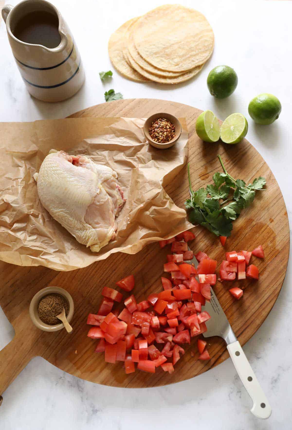 ingredients for chicken tortilla soup laid out on a wooden countertop