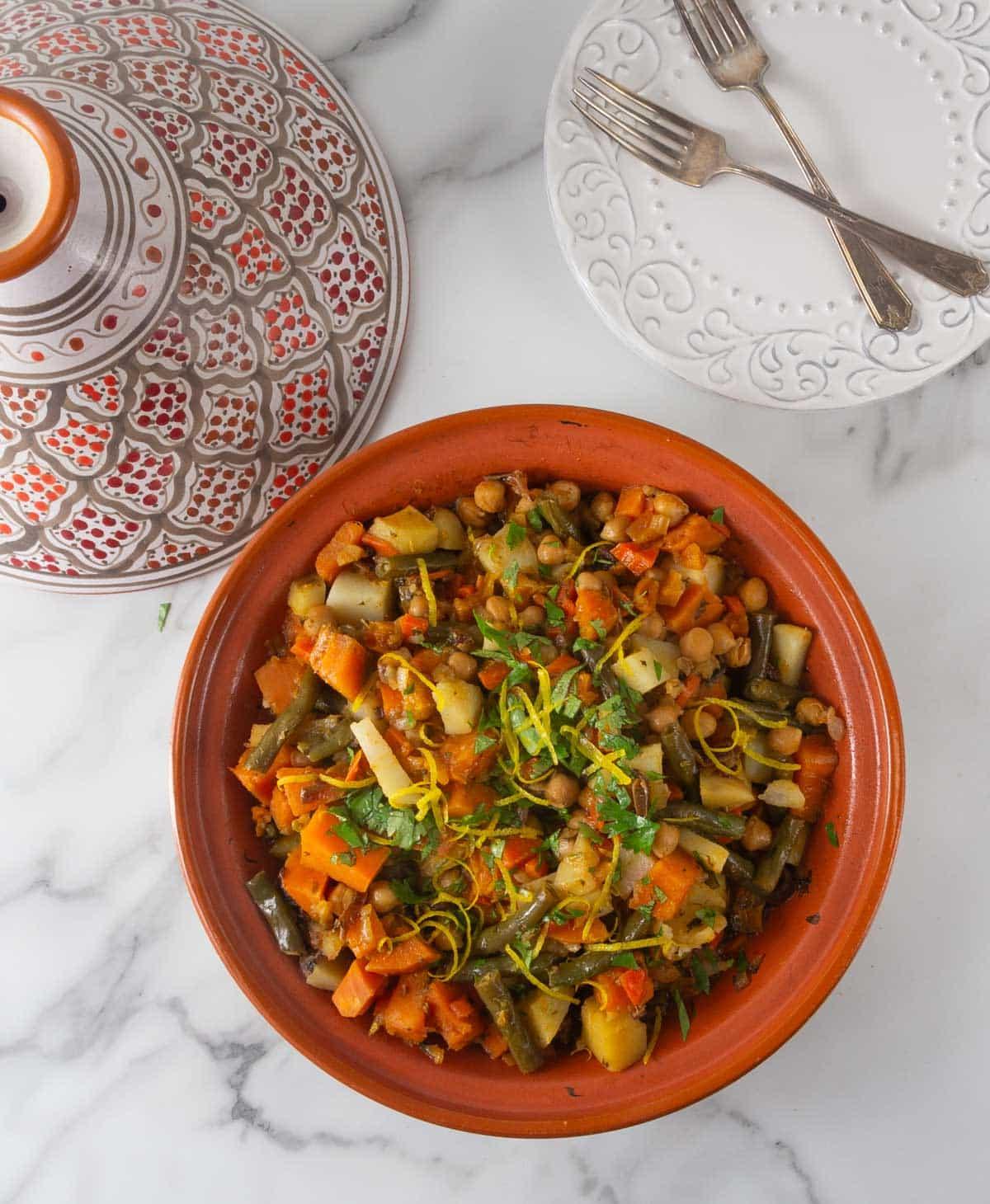 overhead shot of a pot of carrot and chickpea tagine simmering on a stove