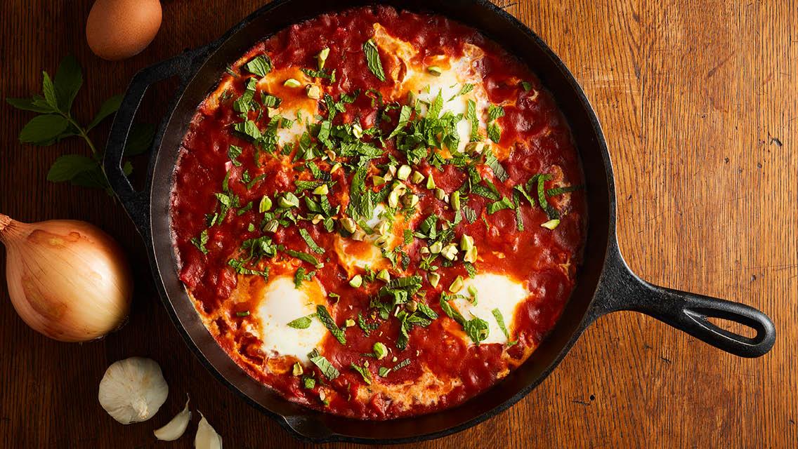 Close-up shot of Shakshuka with Raspberries and Pistachios in a pan