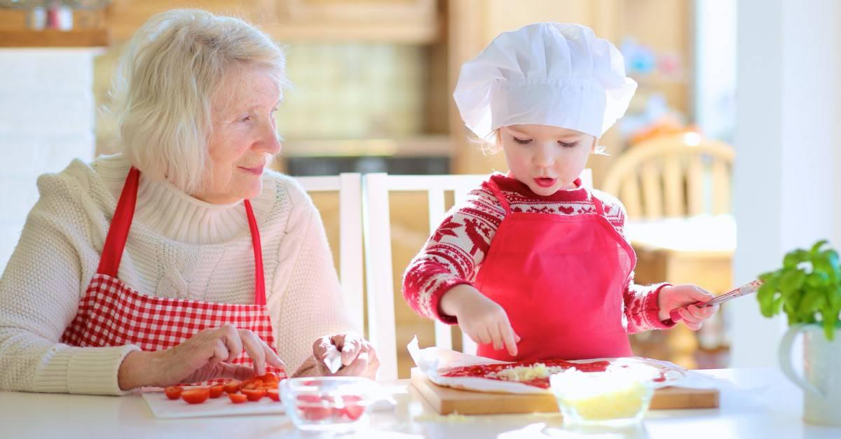 a grandma teaching her grandchild how to cook paella