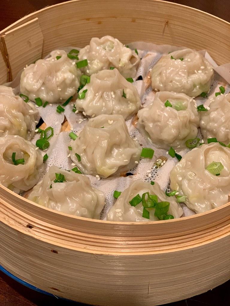 steaming callaloo and crabmeat stuffed dumplings on a bamboo steamer