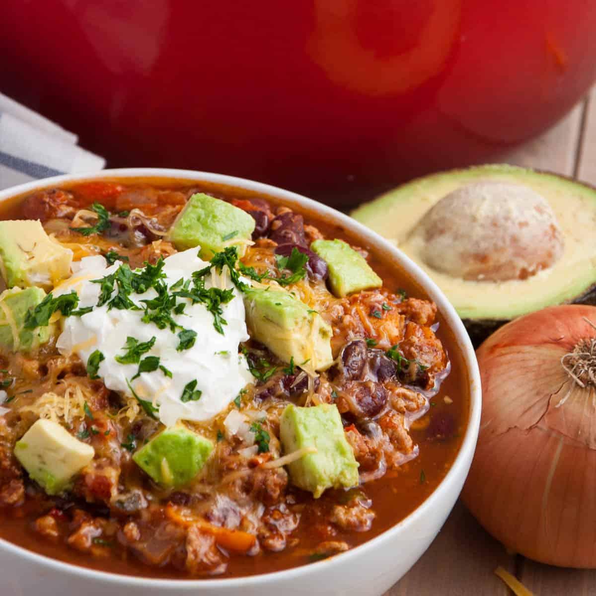 A close-up shot of a pot of simmering turkey and vegetable chili.