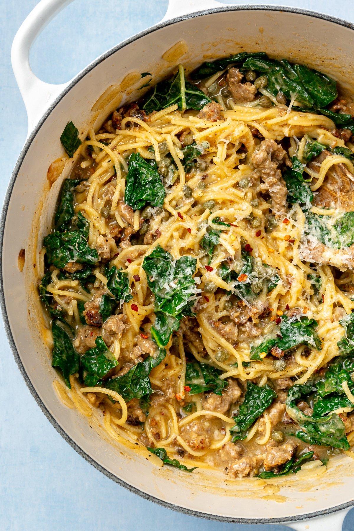 close-up shot of italian sausage and kale one-pot pasta being served in a bowl