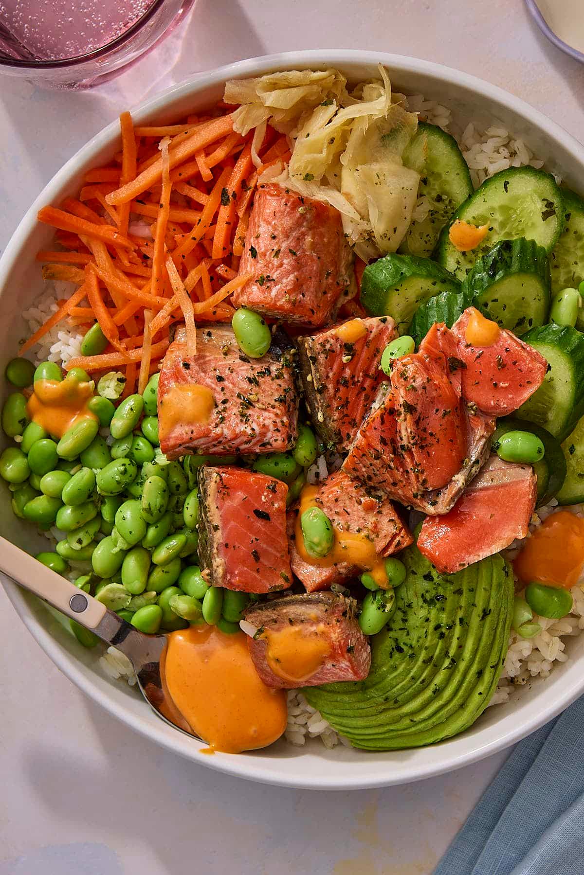 top-down view of assembling a salmon poke bowl