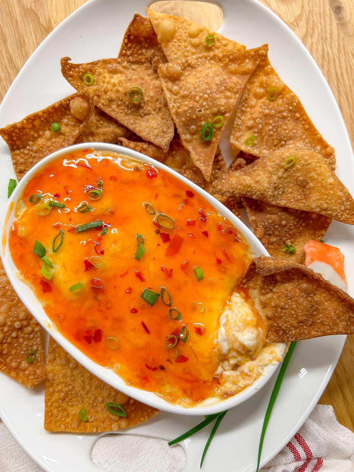 aerial view of crab rangoon dip in a baking dish, surrounded by wonton chips