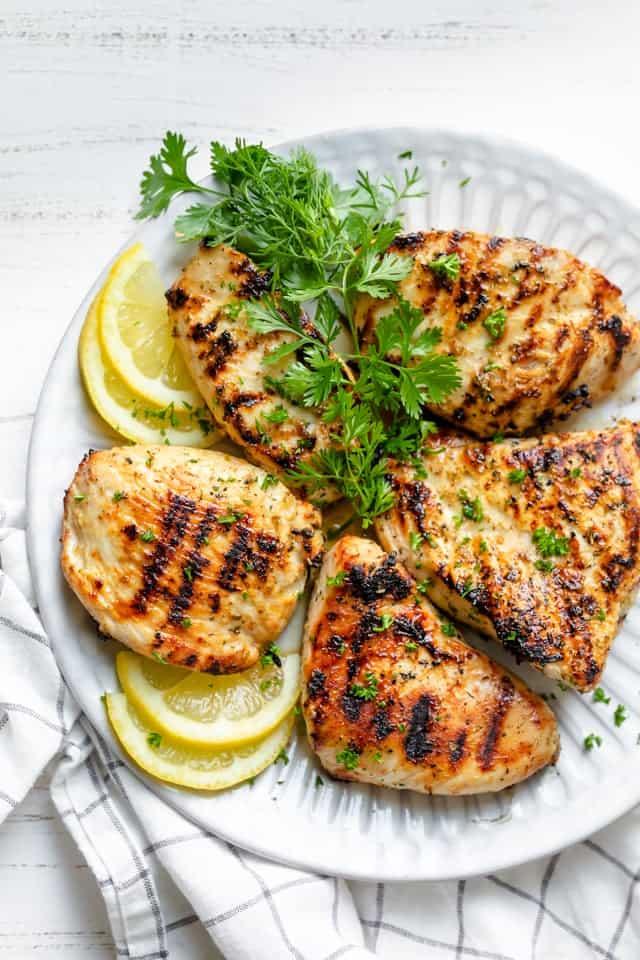 perfectly grilled chicken breast with citrus slices and parsley