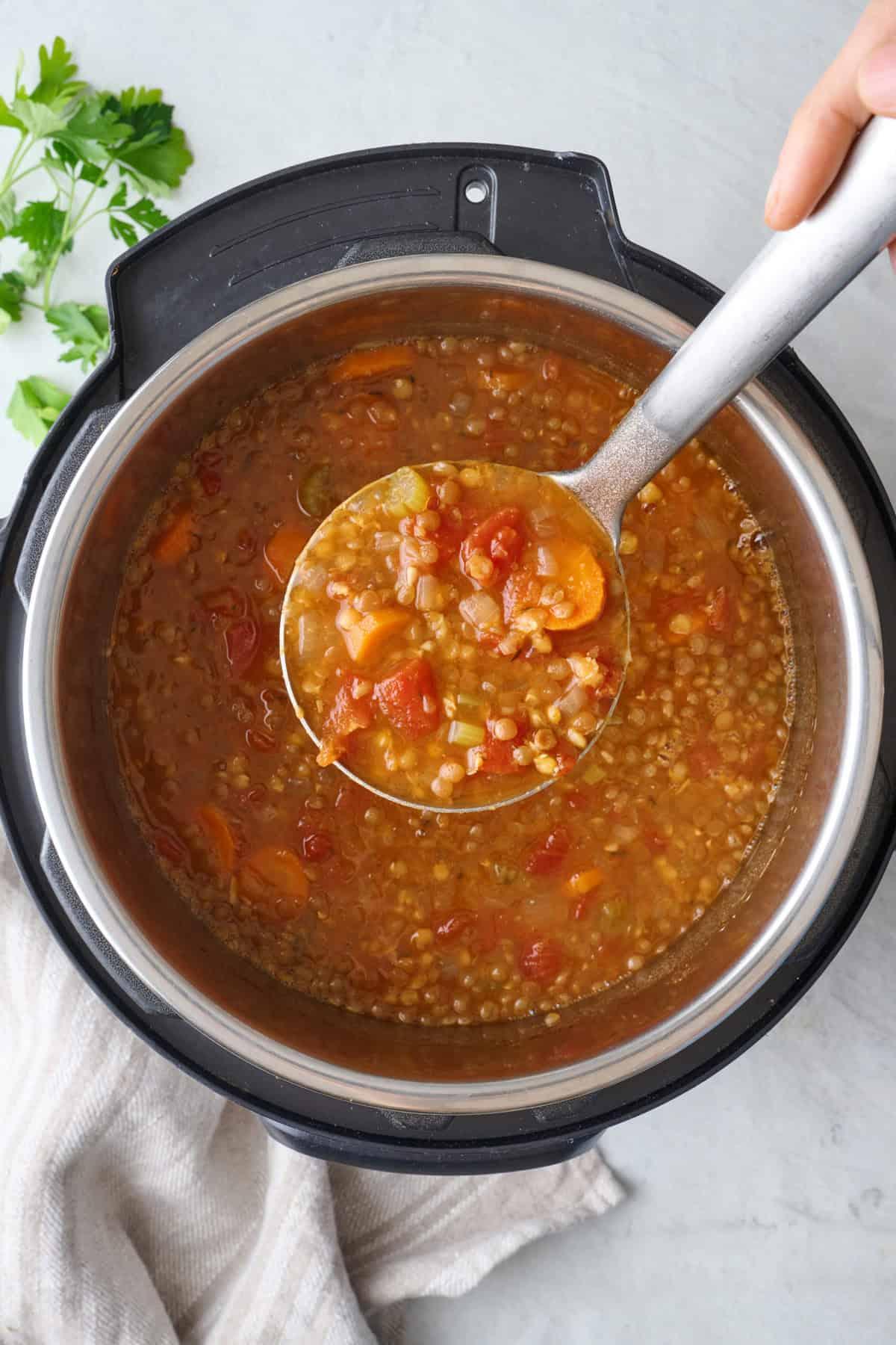 close-up shot of a spoonful of lentil soup being lifted from a bowl