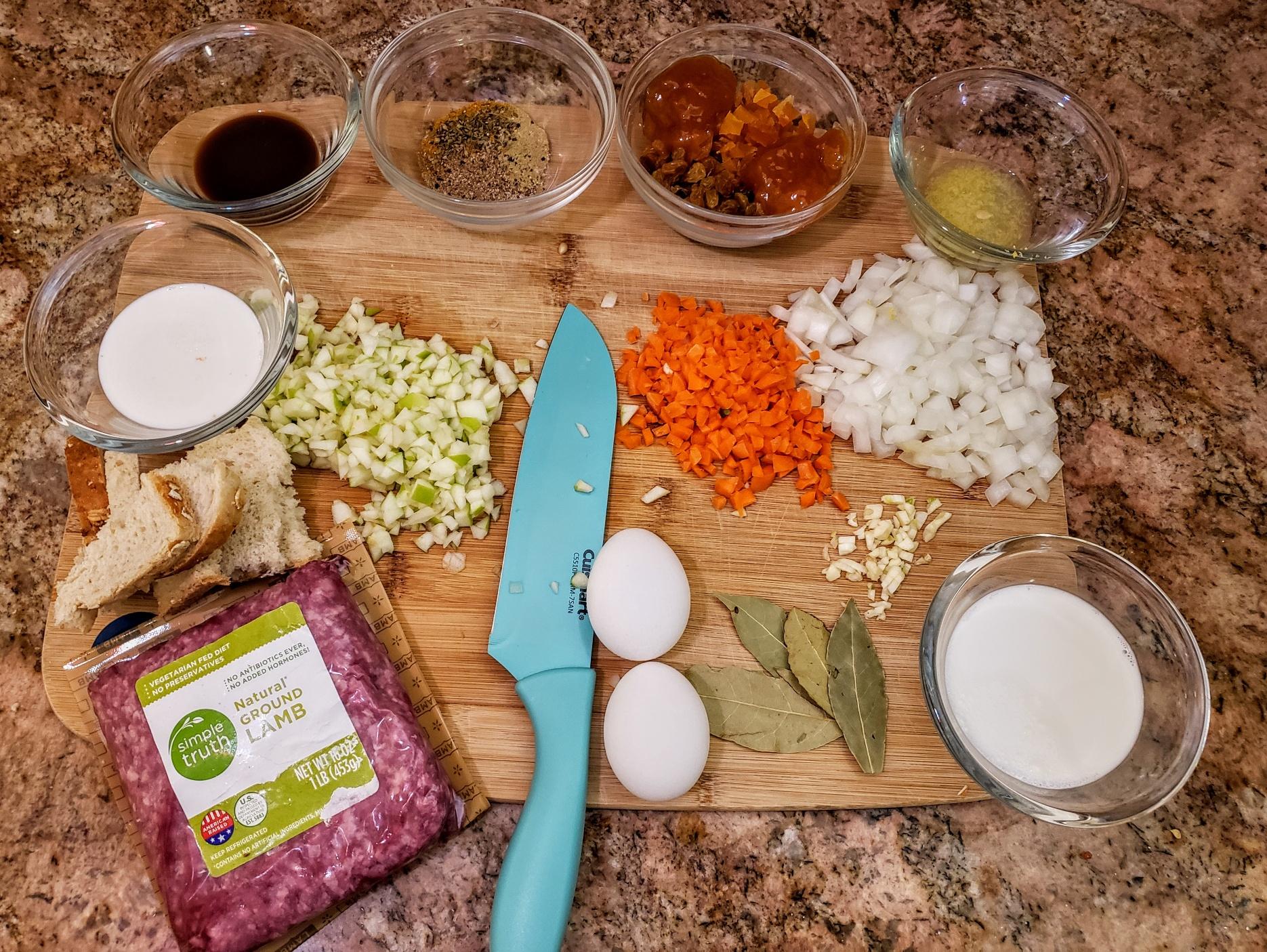Ingredients for Bobotie laid out on a wooden table