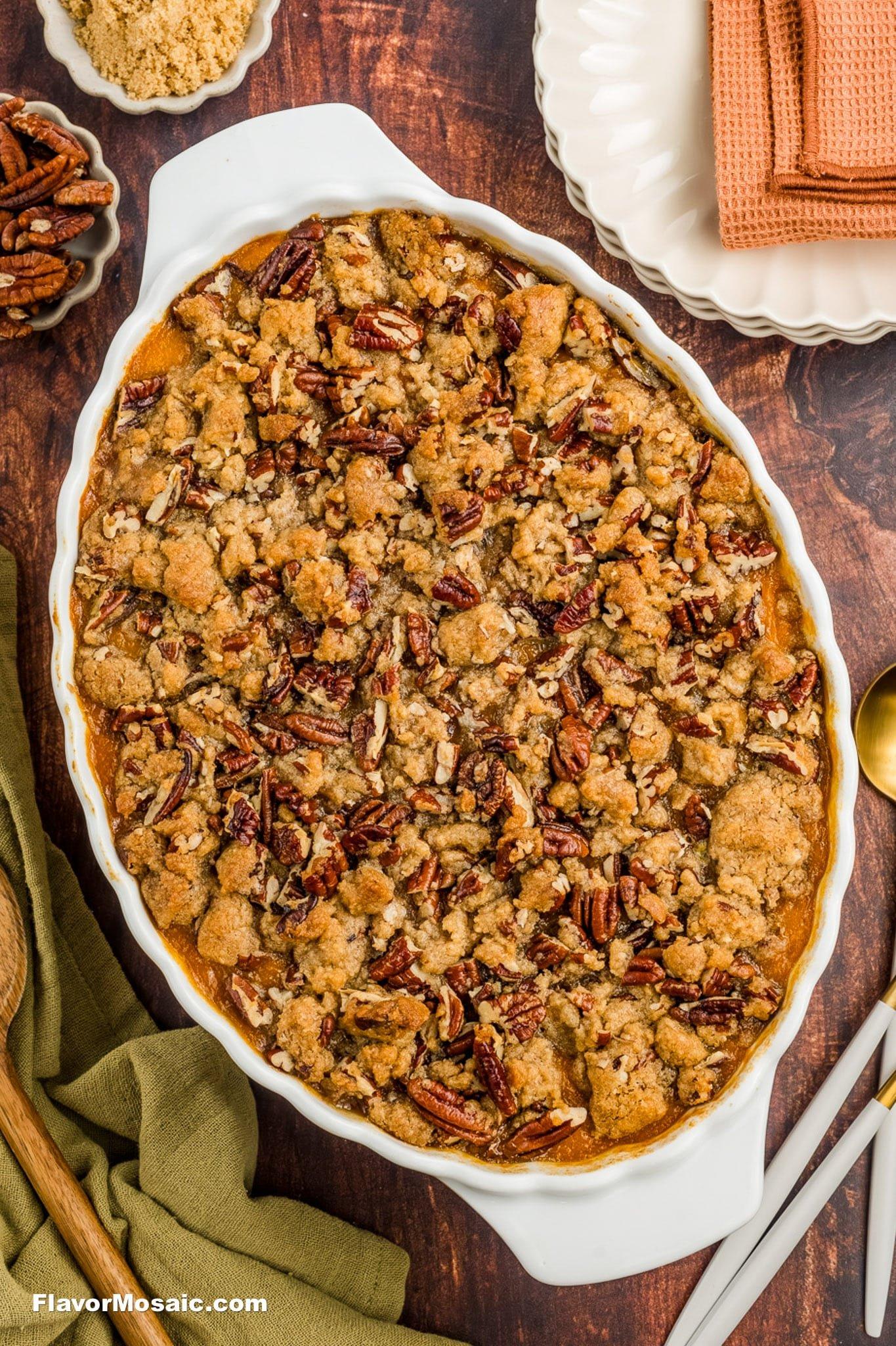 Sweet potato casserole with a golden pecan topping on a rustic wooden table, holiday setting with fall decor