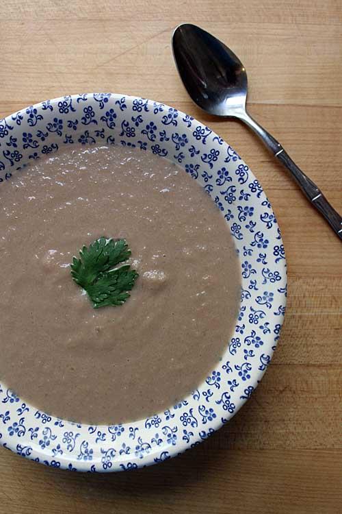 Someone tasting a spoonful of vegan kohlrabi soup