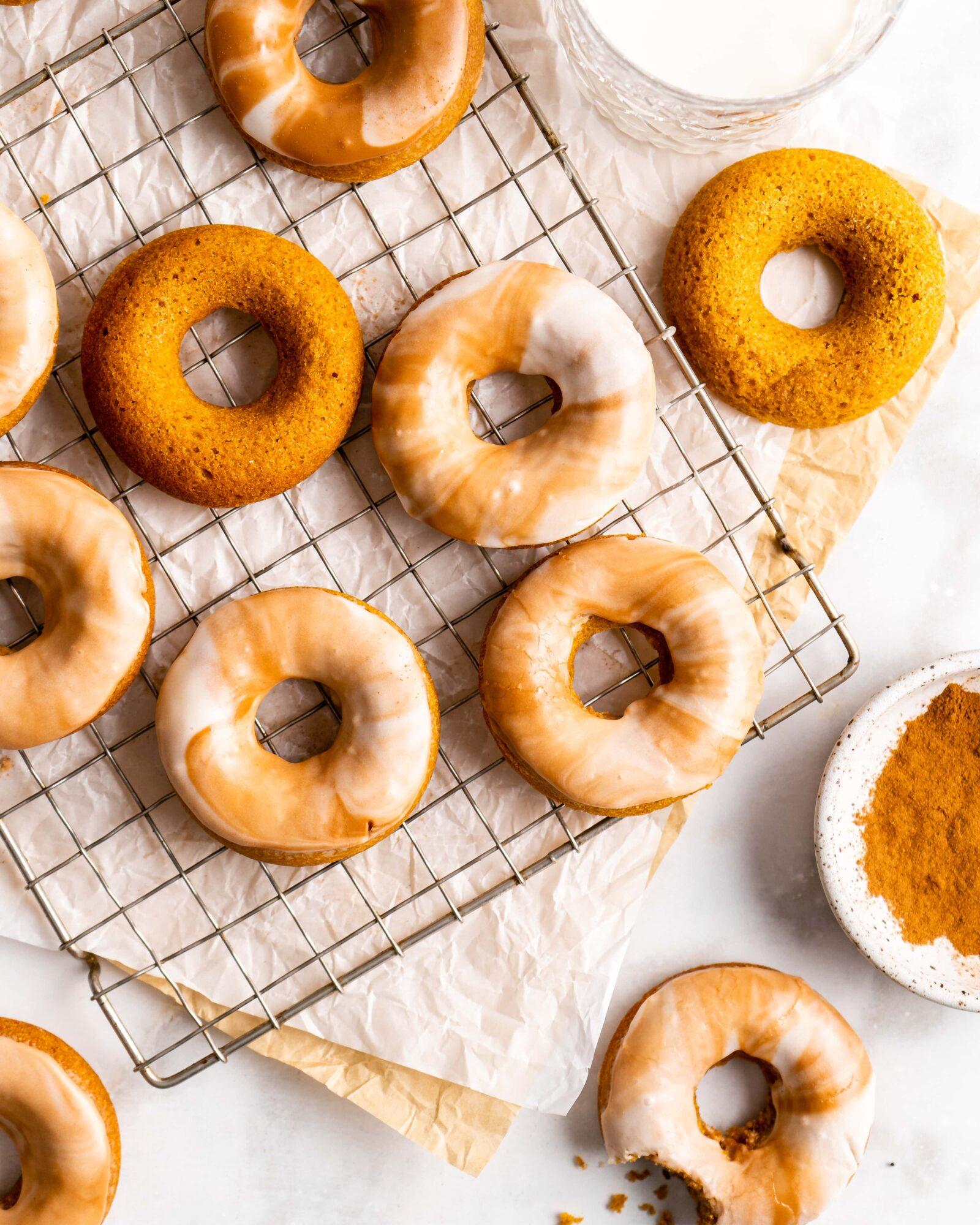 A batch of freshly steamed pumpkin spice latte doughnuts on a wire rack