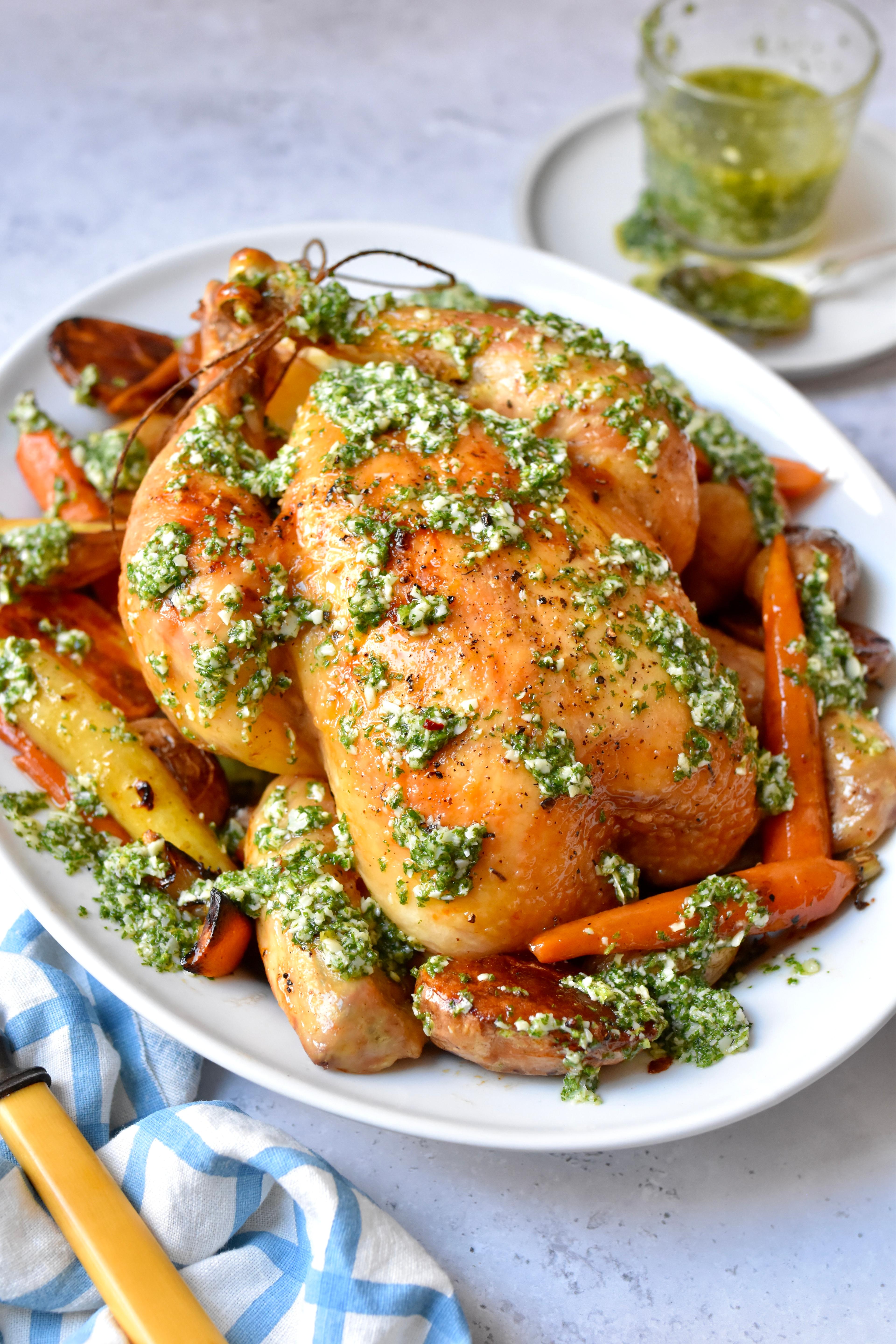 Hand sprinkling fresh parsley over cooked golden skillet chicken
