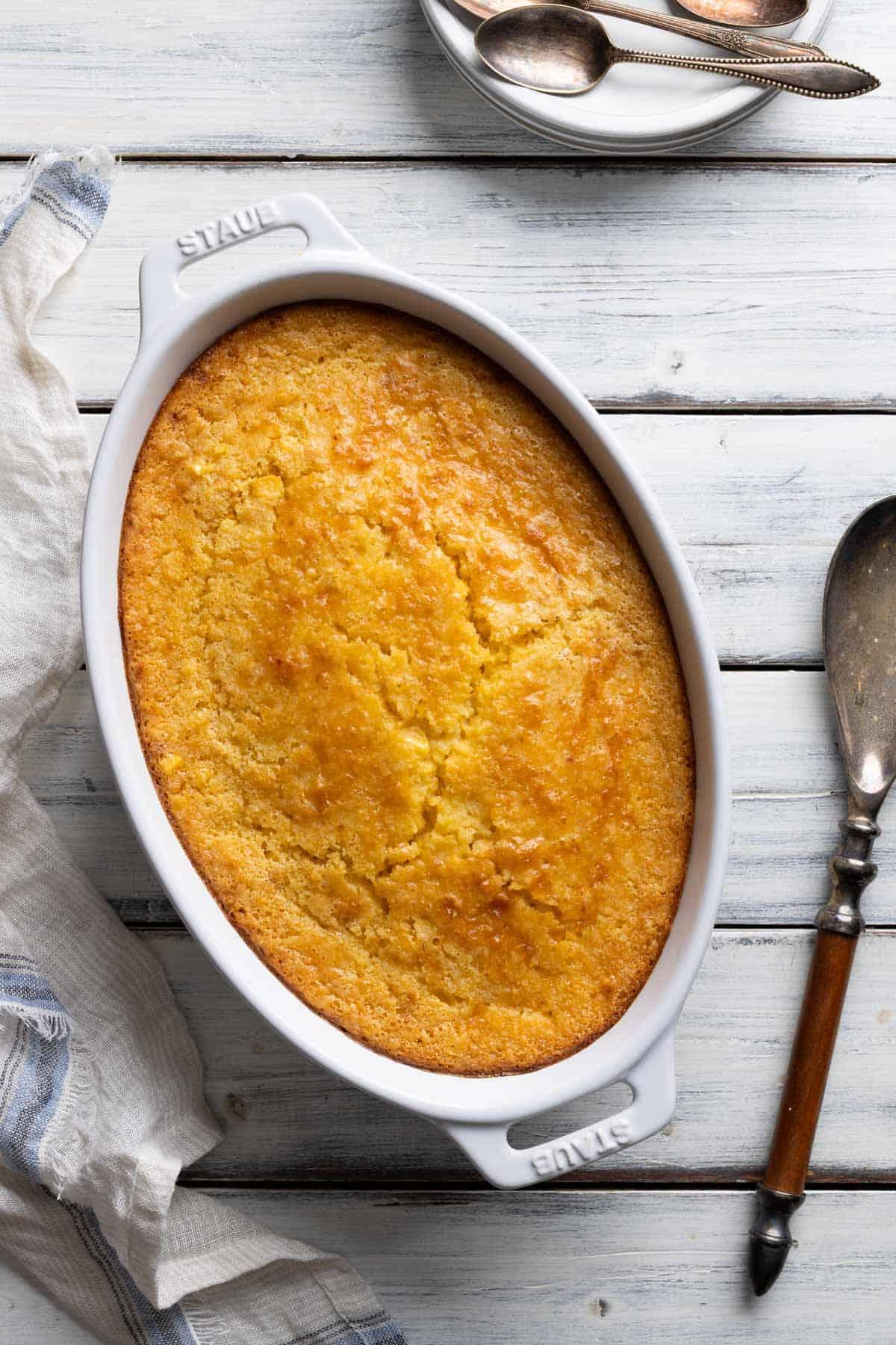 Southern corn casserole on a rustic wooden holiday table with other dishes