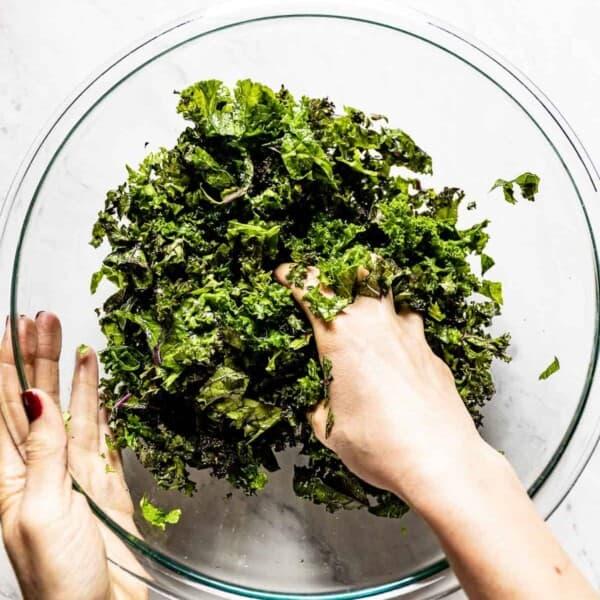 person massaging kale