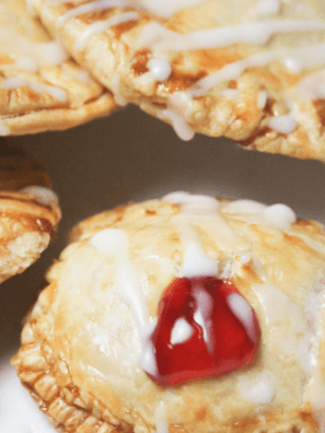 Close-up shot of a cherry pie donut being bitten into, revealing the cherry filling