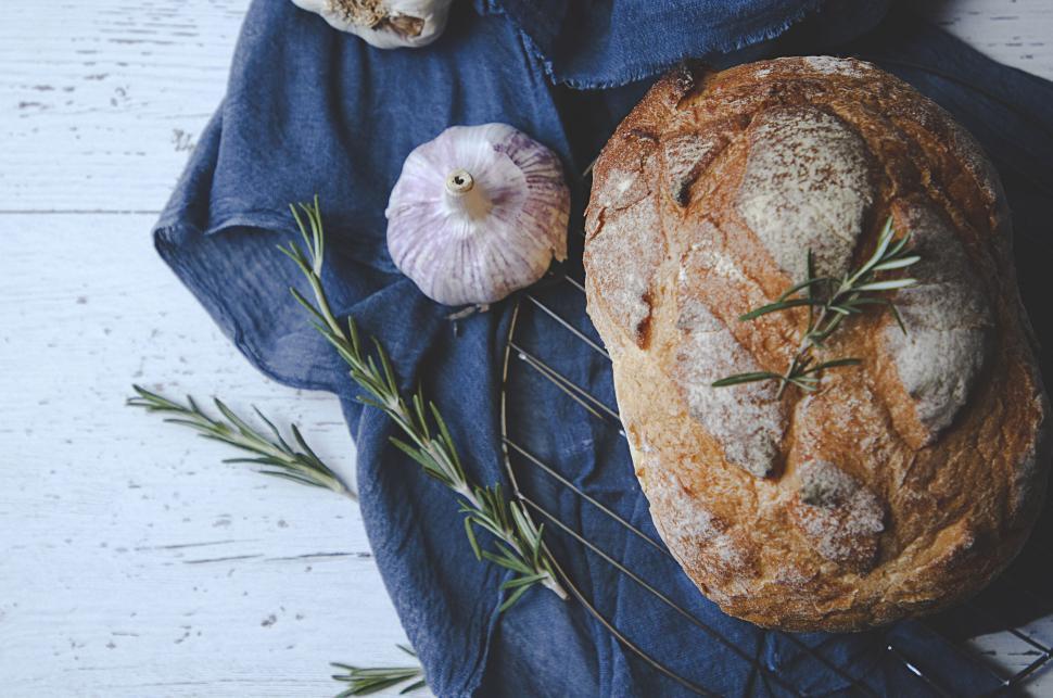 A rustic loaf of sourdough bread cooling on a wire rack.
