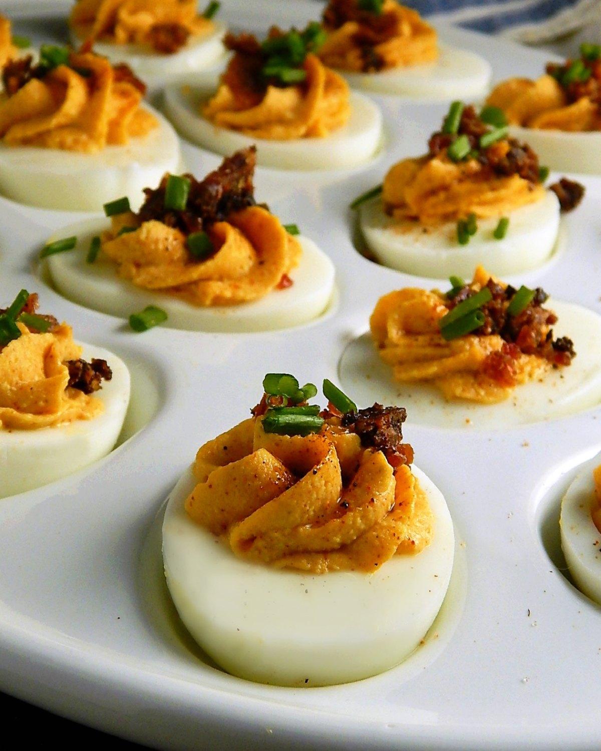 plate of deviled eggs with smoked paprika and chives garnish, natural lighting, close-up