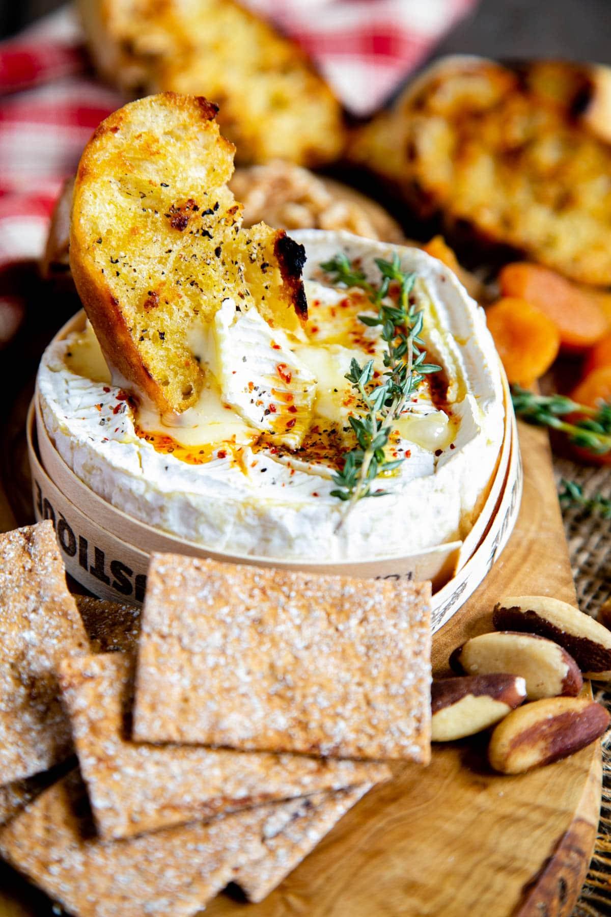 Close-up of baked Camembert cheese with crusty bread for dipping