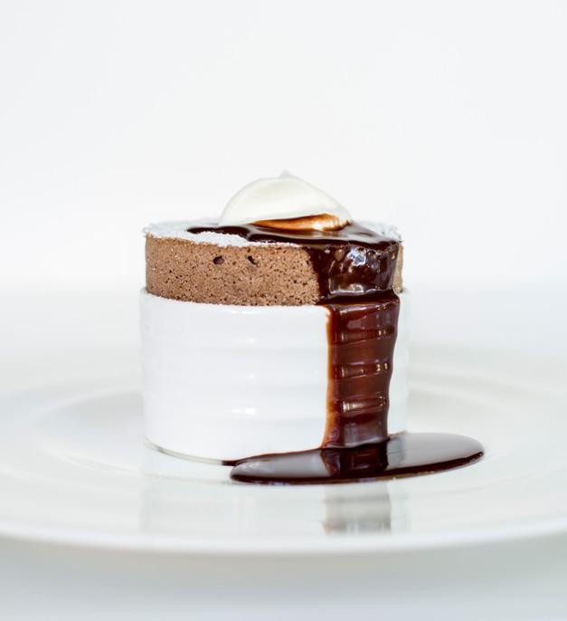 pouring chocolate sauce over injera soufflé