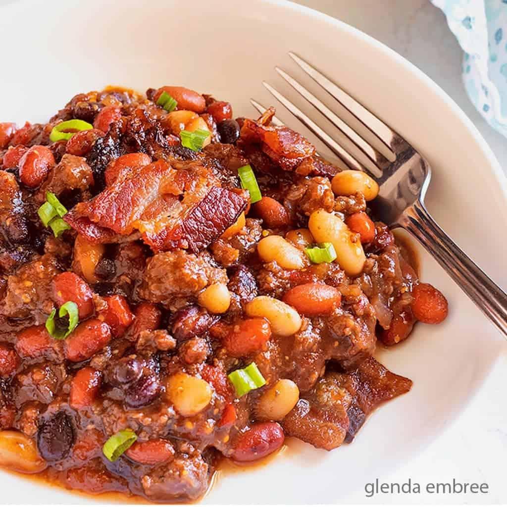 A table laden with BBQ food, including baked bean casserole