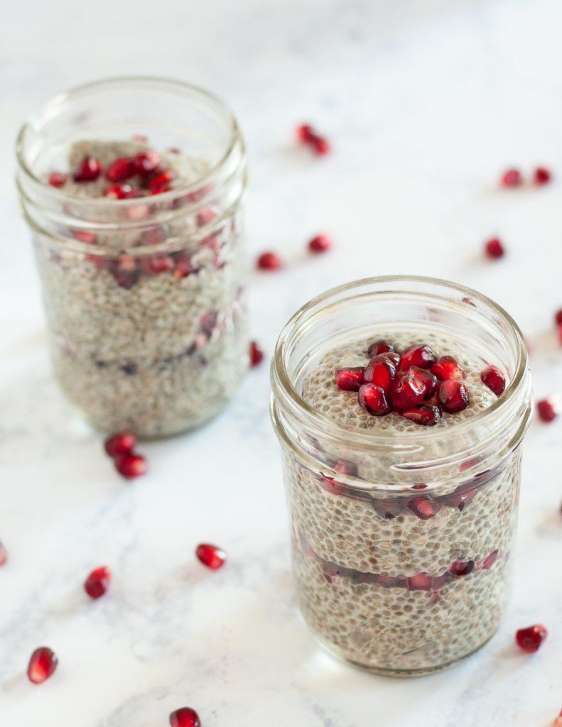 close up of pomegranate almond chia seed pudding in a glass jar